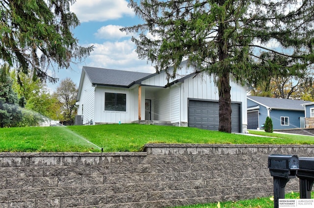 view of front facade with central air condition unit, a front lawn, and a garage