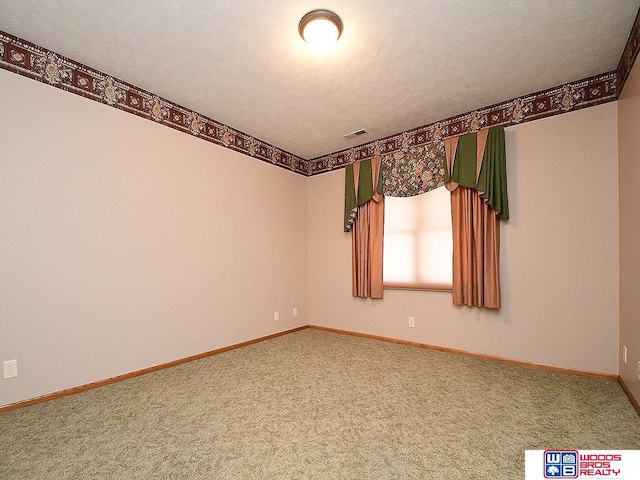 carpeted spare room with a textured ceiling