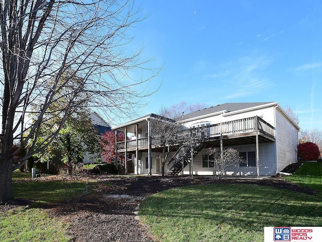 rear view of house with a lawn and a wooden deck