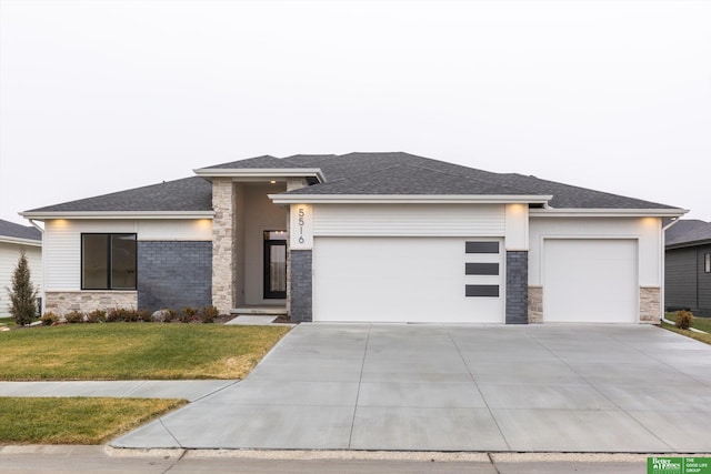 prairie-style house featuring a garage, stone siding, driveway, stucco siding, and a front yard