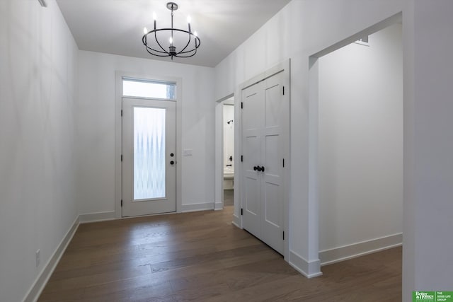 entryway featuring a chandelier, baseboards, and wood finished floors