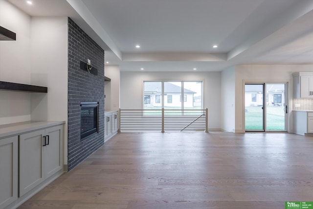 unfurnished living room with a fireplace and light wood-type flooring