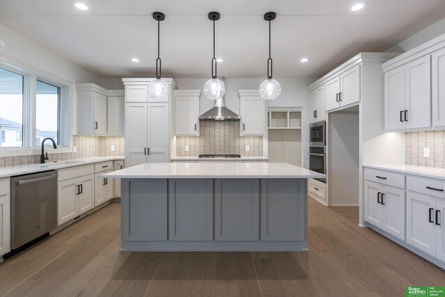 kitchen featuring pendant lighting, stainless steel appliances, white cabinetry, and sink