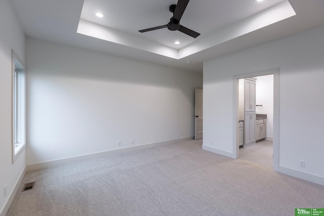 unfurnished bedroom featuring a tray ceiling, visible vents, baseboards, and recessed lighting