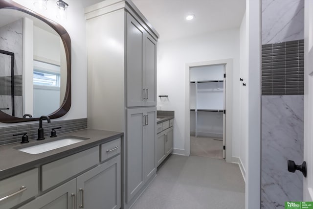 full bath featuring tasteful backsplash, baseboards, a spacious closet, vanity, and recessed lighting