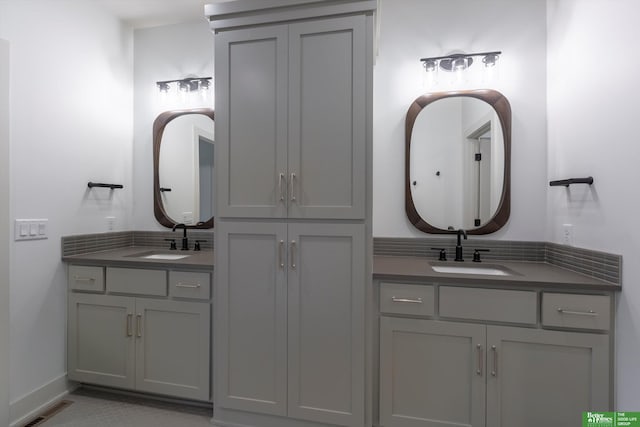 bathroom with two vanities, a sink, and visible vents