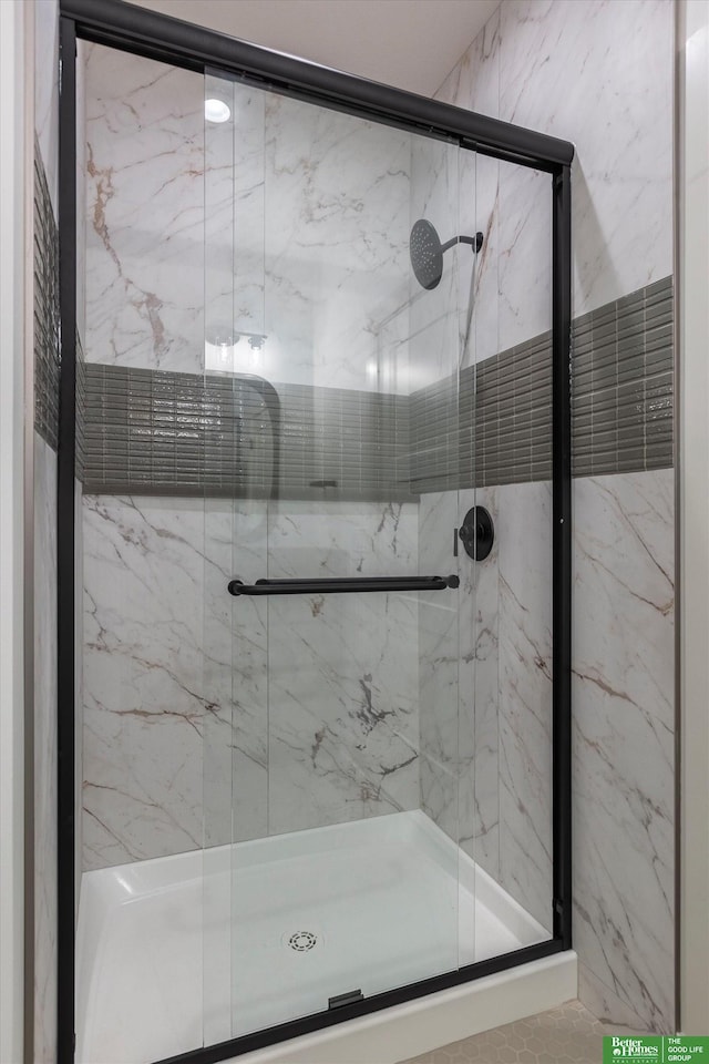 bathroom featuring a marble finish shower