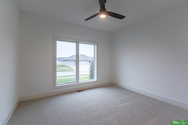 spare room featuring ceiling fan and light carpet