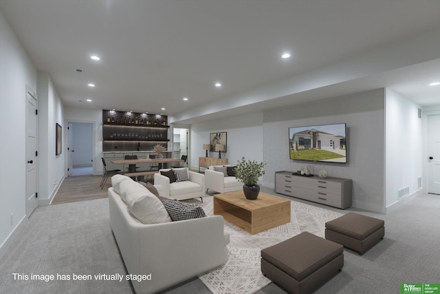 living area with carpet floors, recessed lighting, visible vents, and baseboards