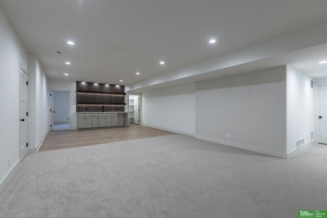 unfurnished living room featuring baseboards, recessed lighting, visible vents, and light colored carpet