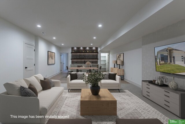 living area featuring baseboards and recessed lighting