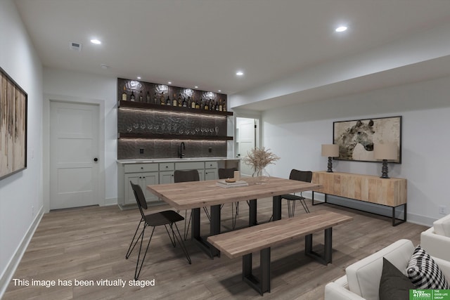 dining space with light wood-type flooring, visible vents, and recessed lighting