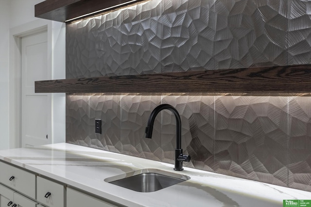 interior details featuring white cabinets and decorative backsplash