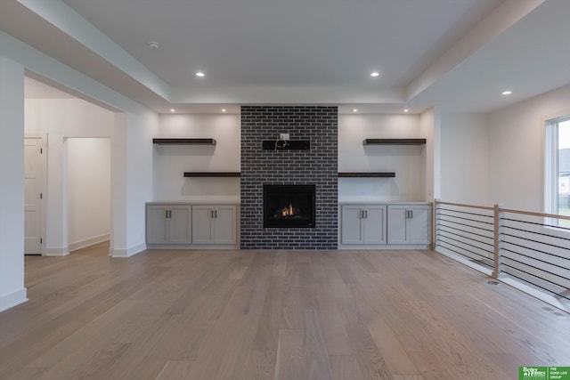 unfurnished living room with light wood-type flooring, a fireplace, and recessed lighting