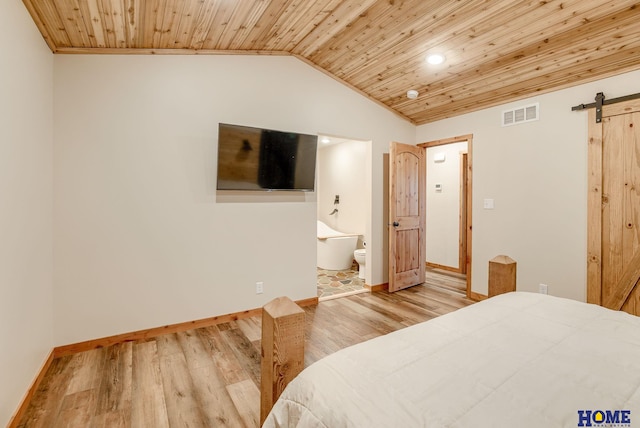 bedroom with wood ceiling, vaulted ceiling, a barn door, light hardwood / wood-style flooring, and connected bathroom