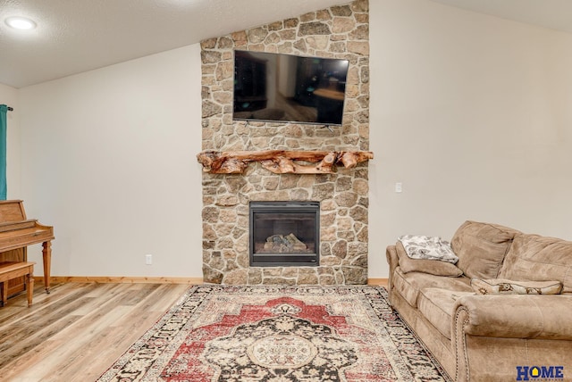 living room featuring a large fireplace, hardwood / wood-style floors, and lofted ceiling