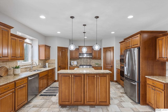 kitchen featuring stainless steel appliances, a center island, pendant lighting, sink, and backsplash