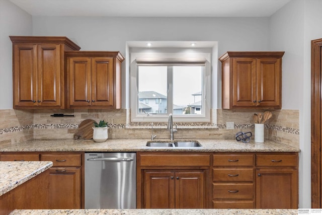 kitchen with sink, light stone counters, stainless steel dishwasher, and backsplash