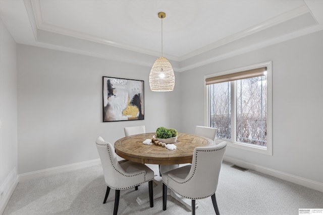 dining area with light carpet, a wealth of natural light, a tray ceiling, and crown molding