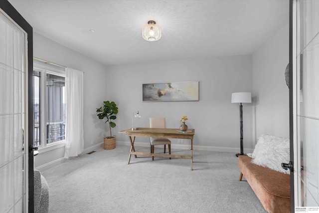 office area with a textured ceiling and light carpet