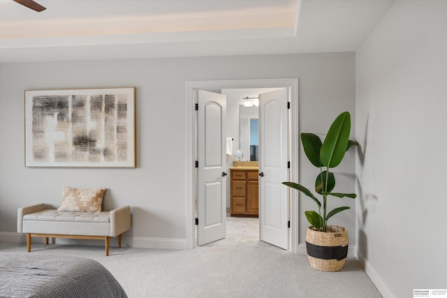 bedroom featuring ceiling fan, ensuite bathroom, and light carpet