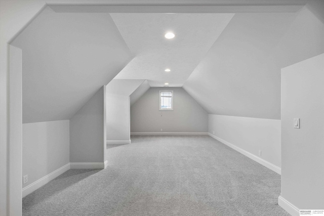 additional living space with light colored carpet and lofted ceiling