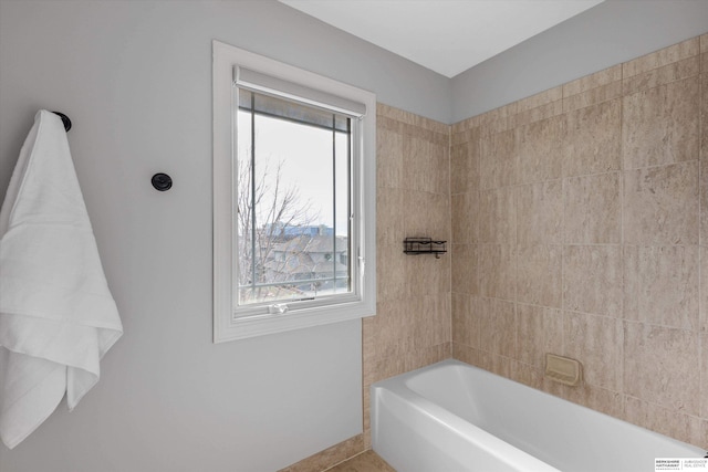 bathroom featuring a healthy amount of sunlight, a bath, and tile patterned flooring