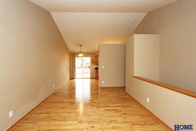 unfurnished room with ceiling fan, light hardwood / wood-style flooring, and vaulted ceiling