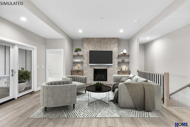 living room featuring light hardwood / wood-style flooring and a stone fireplace