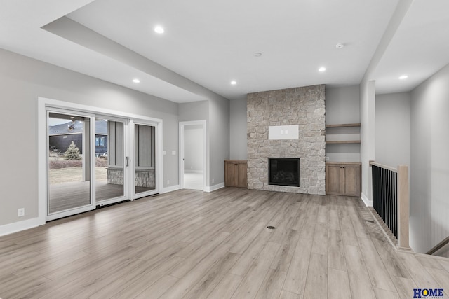 unfurnished living room with a fireplace and light wood-type flooring