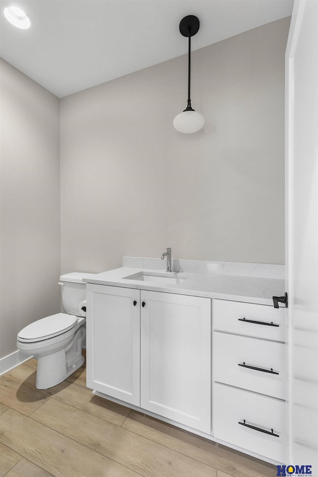 bathroom featuring hardwood / wood-style floors, vanity, and toilet