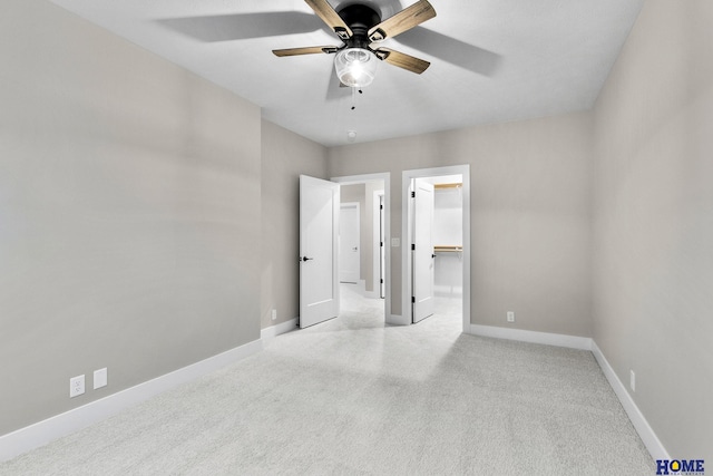 unfurnished bedroom with ceiling fan, light colored carpet, and a spacious closet