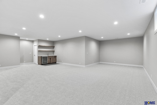 unfurnished living room featuring light colored carpet and indoor bar