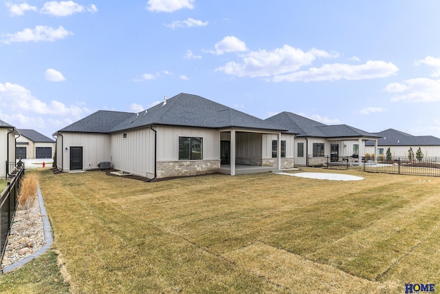 back of property with a lawn and a patio