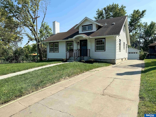 view of front facade with an outbuilding, a garage, and a front lawn