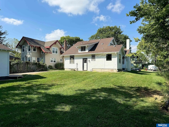 rear view of property featuring a yard