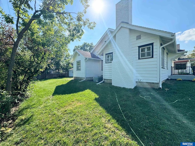 back of property featuring a yard and central air condition unit