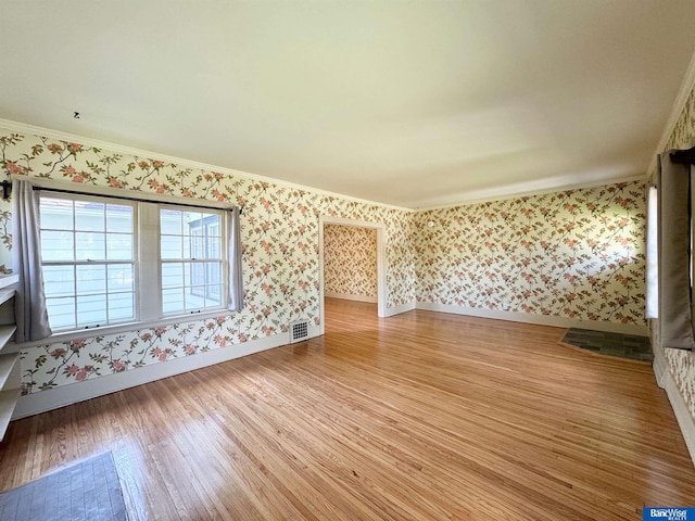 interior space with ornamental molding and light hardwood / wood-style flooring