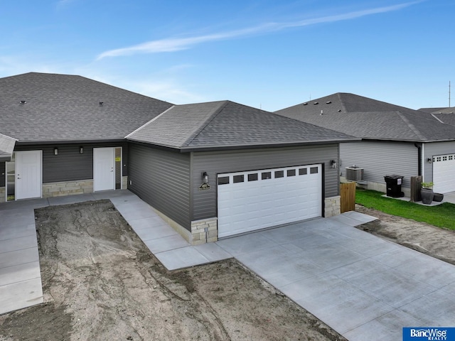 view of front of property featuring a garage and central AC unit