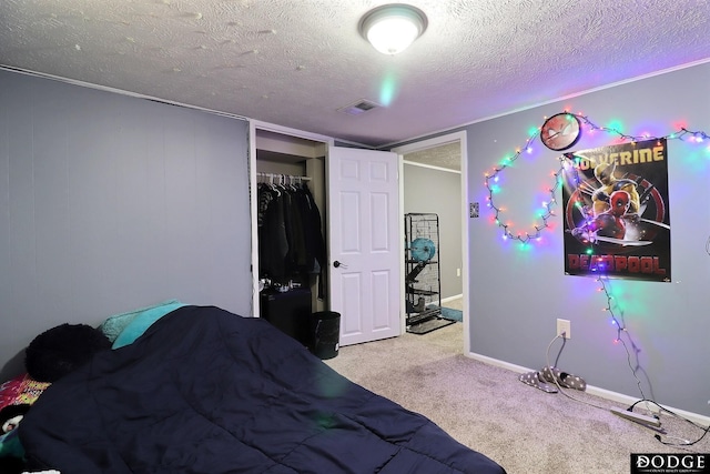 bedroom with a textured ceiling, carpet floors, and a closet