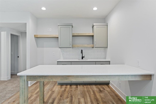 kitchen featuring gray cabinetry, sink, and tasteful backsplash