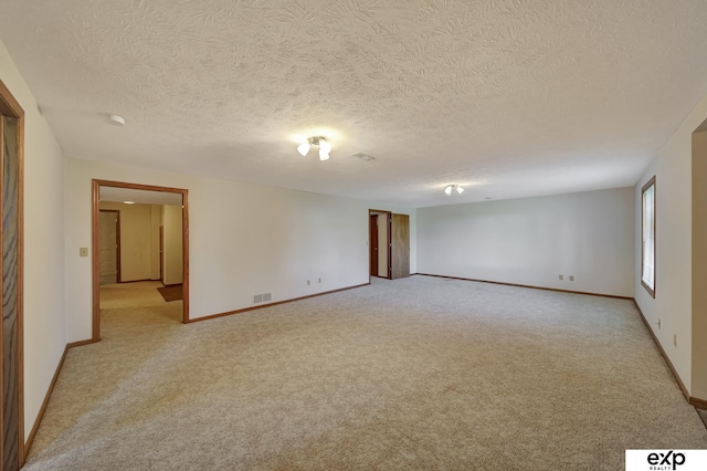 unfurnished room with light carpet and a textured ceiling