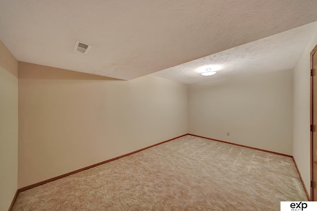 interior space featuring light carpet and a textured ceiling