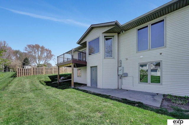 back of property featuring a lawn, a patio area, and a deck