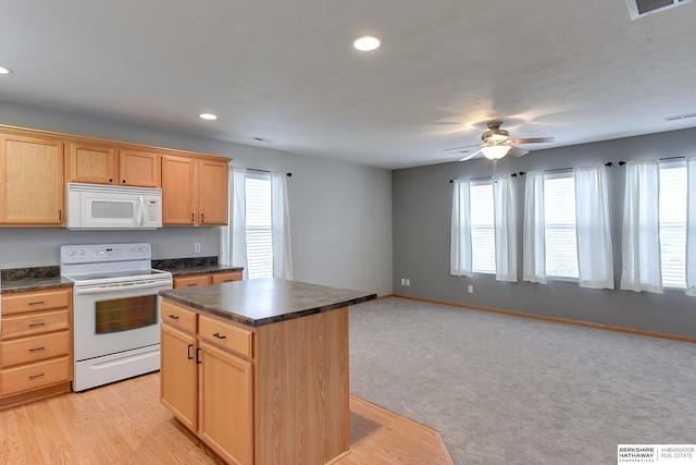 kitchen featuring white appliances, a center island, plenty of natural light, and ceiling fan