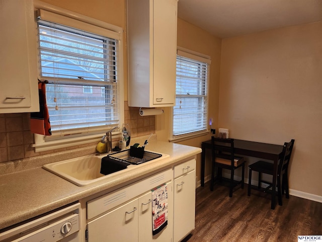 kitchen with backsplash, white cabinetry, stainless steel dishwasher, and sink