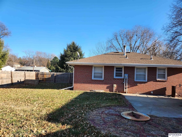 back of property with a lawn and a patio