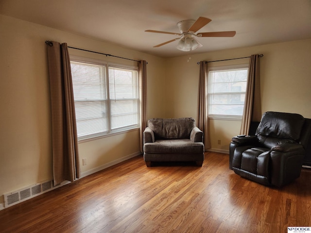 living area with light hardwood / wood-style flooring and ceiling fan