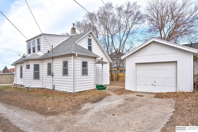 view of side of home with a garage and an outdoor structure