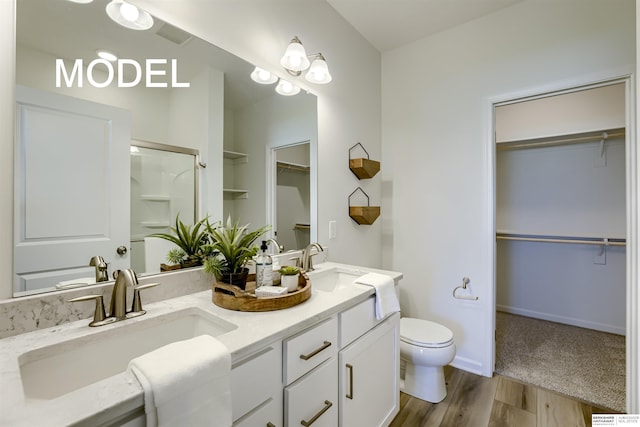 bathroom with toilet, vanity, an enclosed shower, and hardwood / wood-style flooring